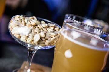 Salted peanuts for beer. Nuts with beer on a blurred background