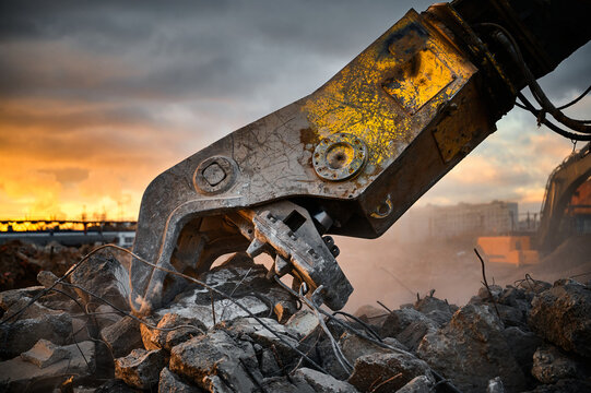 Metal crusher on excavator rigging destroys armored concrete
