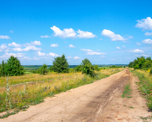 Gravel road going through field.