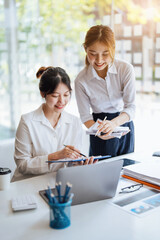 Obraz premium Negotiation, Analysis, Discussion: Portrait of an Asian woman economist and marketer pointing to a financial data sheet to plan investments to prevent risks and losses for the company