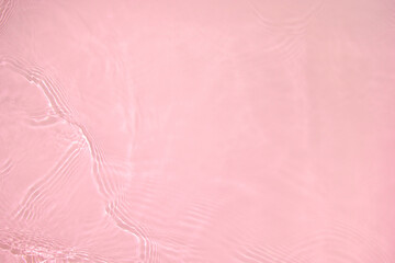 Fototapeta premium Transparent pink colored clear water surface texture with ripples, splashes and bubbles. Abstract nature background Water waves in sunlight with copy space Cosmetic moisturizer micellar toner emulsion