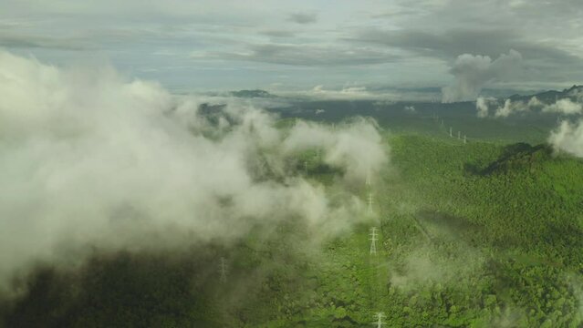 Video 4K, Aerial view Morning scenic on high mountains with electricity pylon Pang Puay, Mae Moh, Lampang, Thailand. Beautiful morning with golden sunrise and fog flowing.
