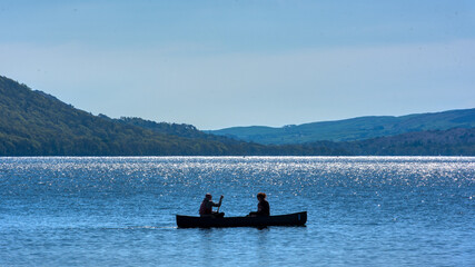 Coniston, United Kingdom - 21st April 2022 : A rowing boat silhouetted on Coniston Water © Sean