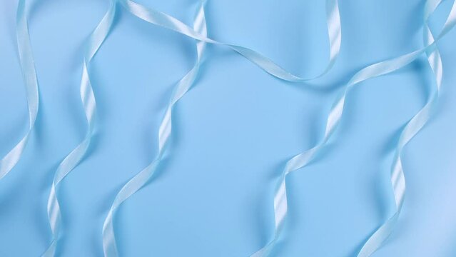 blue background with satin ribbons, concept of boy and newborn birthday celebration or blue party.