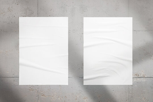 Two posters on the interior wall with a window light over. Blank posters for design presentation. Crumpled texture