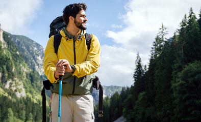 Young man traveling with backpack hiking in mountains