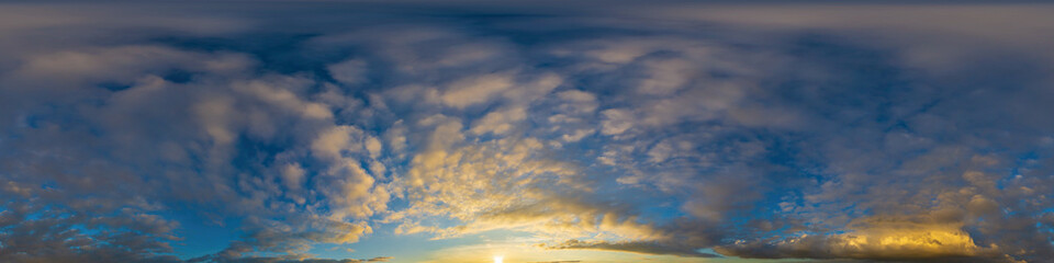 Obraz premium Panorama of a dark blue sunset sky with golden Cumulus clouds. Seamless hdr 360 panorama in spherical equiangular format. Full zenith for 3D visualization, sky replacement for aerial drone panoramas.