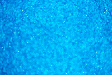 Background light bokeh texture. Beautiful festive Christmas background for the design of congratulations. Nacreous sparkling blue texture.