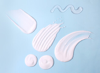 Different skin care product texture swatches like face wash, lotion, scrub, cream, moisturiser on blue background.