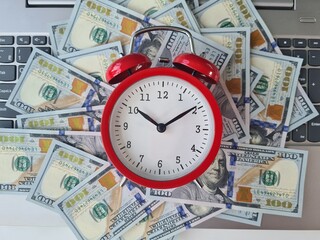 Top view of a keyboard with dollars and an alarm clock
