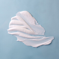 White skin care product texture spread on blue background.