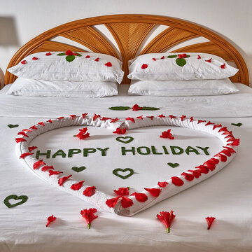 Resort bedroom interior. Bed decorated with flowers. Happy holidays in the Maldives