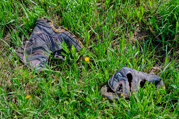 Discarded old rotten shoes, pollution of ecology and nature.