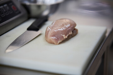raw piece of meat on a cutting board. raw piece of meat on a white blastmass cutting board, close-up