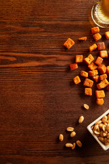 Overhead view of wooden table framed with snacks, nuts and chips. Copy space