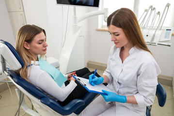  medicine, stomatology and health care concept - close up of dentist with clipboard and happy...