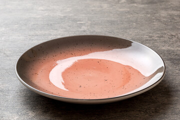 Perspective view of empty red plate on cement background. Empty space for your design