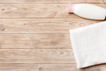 Cosmetic shampoo bottle mockup with towels on a colored table. Bathroom background, toilet accessories for hand and body care