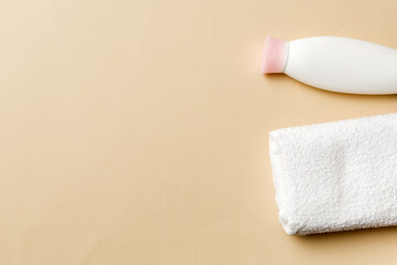 Cosmetic shampoo bottle mockup with towels on a colored table. Bathroom background, toilet accessories for hand and body care