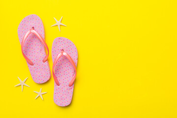 Flat lay composition with flip flops and seashell on colored background. Space for text top view