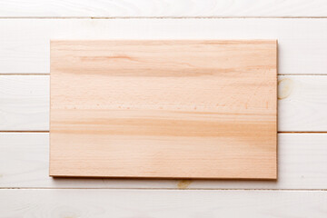Top view of wooden cutting board on wooden background. Empty space for your design.=