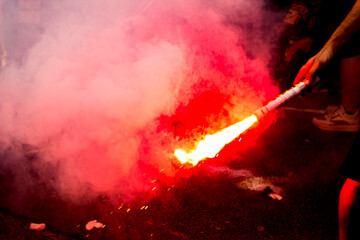 Closeup of a red smoke bomb from fans in front of an Italian stadium.