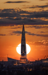 Skyscraper Lakhta center and St. Isaac's Cathedral against the backdrop of the setting sun. Saint-Petersburg, Russia.