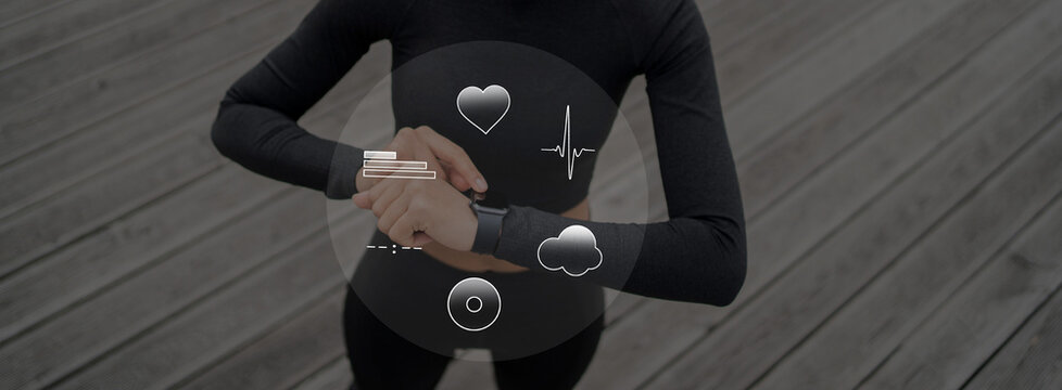 Uses a pulse smartwatch on her hand for sports, running and body warm-up, a sporty woman