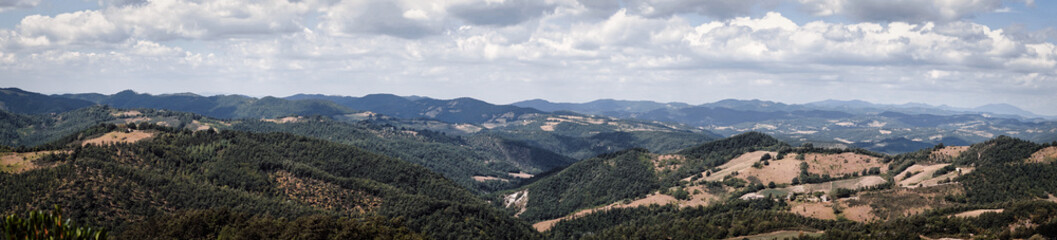 Panoramic view of Marche hills. Italian countryside in central Italy, in the Marche region. Mountains, hills and forests under blue skies. Hot summer and climate change. Osimo, Ancona, Urbino.