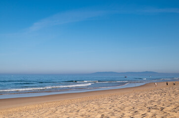Sea beach with sand and waves. Sunny day.