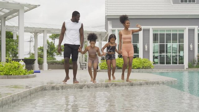 Group of relaxed black african american family, dad, mother and daughter playing by the swimming pool in summer season. People lifestyle in travel holiday vacation concept. Relaxation.