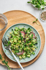 Fresh salad with avocado, bulgur, cucumber, radish and microgreens