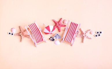 Seashells, folding beach chairs and starfish, on a pink background. Still life of summer vacation