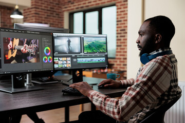 Digital footage professional editor at multi monitor workstation improving visual quality of...