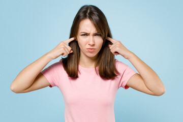 Fototapeta premium Young sad caucasian woman 20s wearing pink t-shirt cover ears with hands fingers do not want to listen scream isolated on pastel plain light blue background studio portrait. People lifestyle concept.