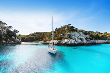 Beautiful beach with sailing boat yacht, Cala Macarelleta, Menorca island, Spain. Yachting, travel...