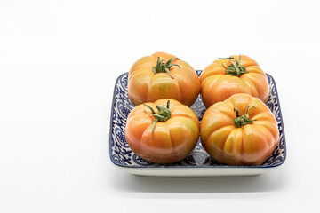 Tomatoes for salad in ceramic plate isolated on a white background