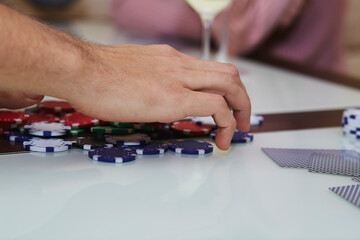 Player in poker game with chips, cards on the table with reflection. Enjoying the moment with friends, digital detox. Lifestyle photography. Candid moment. Selective focus.