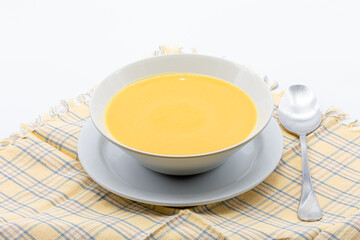 pumpkin and carrot cream with toasted bread in a ceramic bowl isolated on a white background
