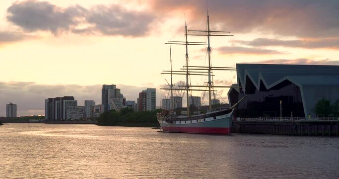 Glasgow, Scotland, UK - May 20 2022 Glasgow Tall ship on river clyde next to transport museum at golden hour sunset