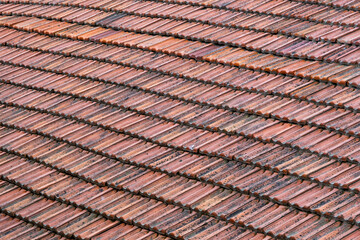 Weathered roof tile in dark orange color, old and dirty tiles, wide angle