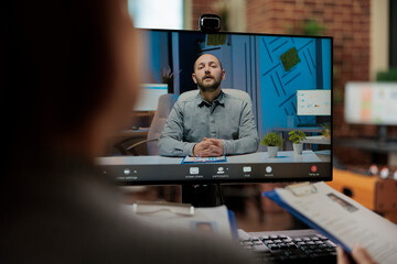 Businesswomen reading cv discussing application plan with remote candidate during online videocall meeting conferene in startup company office. Hiring teleconference call on computer screen