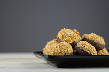 Chocolate nuts on black plate with copy space at the table 