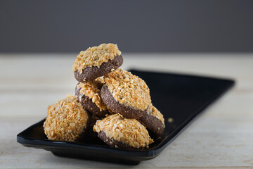 Chocolate nuts on black plate with copy space at the table 