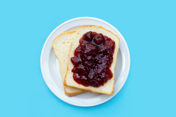 Bread with strawberry jam on blue background