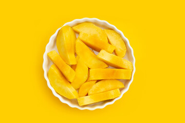Yellow mango slices on yellow background.