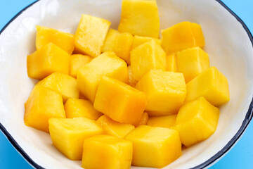 Yellow mango cube slices in white bowl