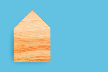 Mini wood house model on blue background.