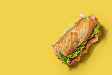 Submarine sandwich with ham, cheese, lettuce, tomatoes,onion, mortadella and sausage on yellow...