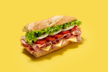 Submarine sandwich with ham, cheese, lettuce, tomatoes,onion, mortadella and sausage on yellow background